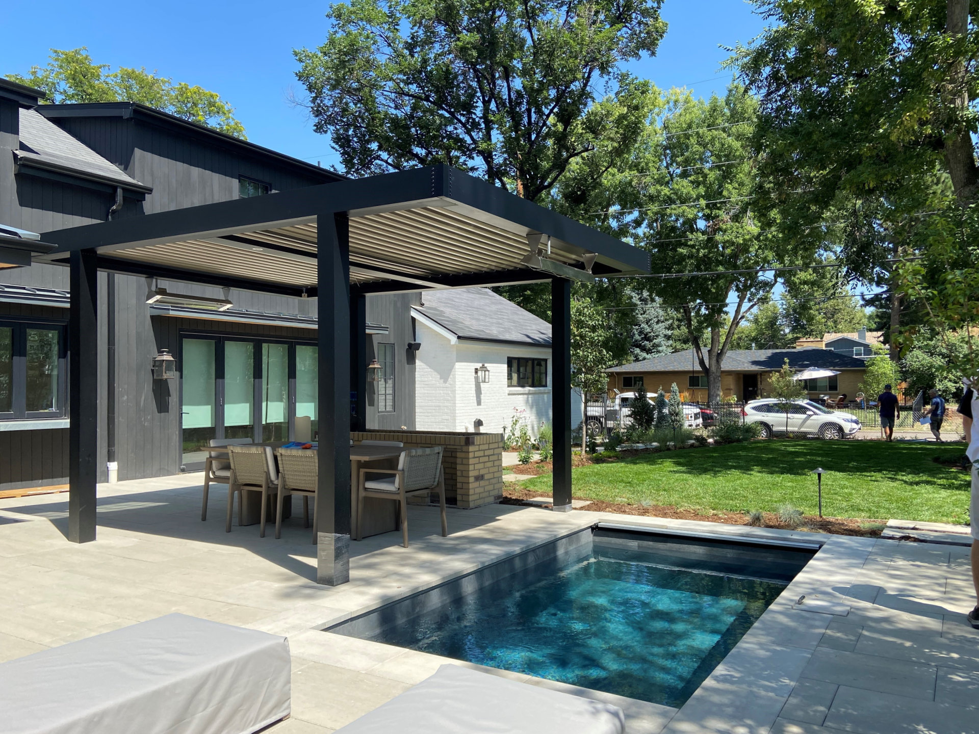 compact backyard plunge pool set into patio beside covered pergola seating area with dining space and clean modern layout