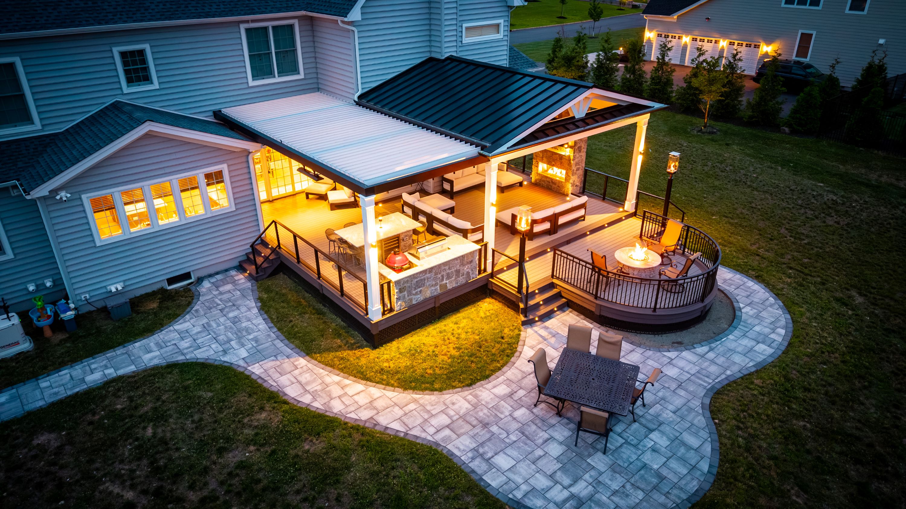 backyard outdoor living space with a louvered roof, a gable roof covered lounge area, outdoor kitchen, fire pit, and patio seating area