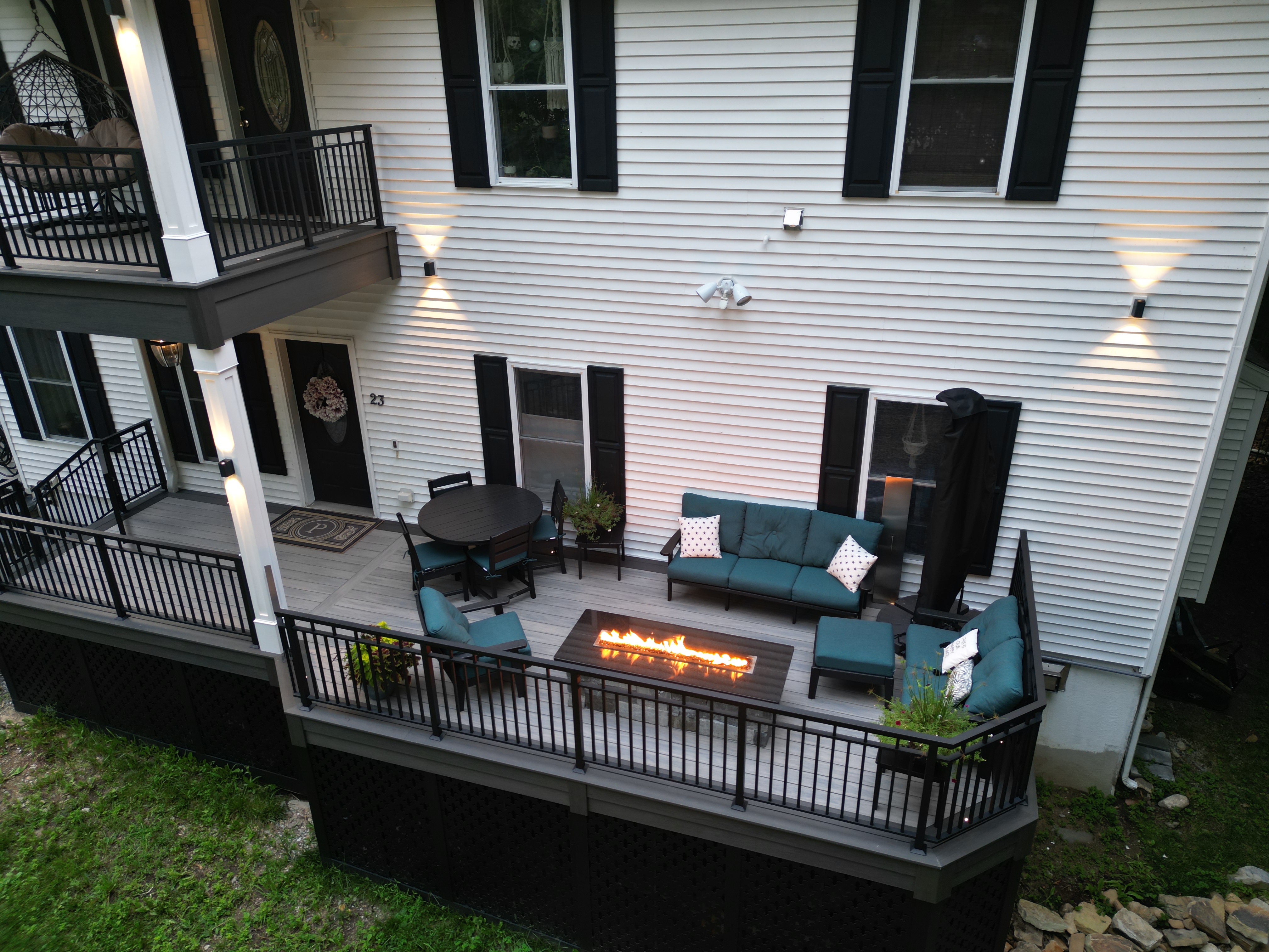 modern raised deck with linear fire table, black railings, outdoor seating area, and integrated step lighting