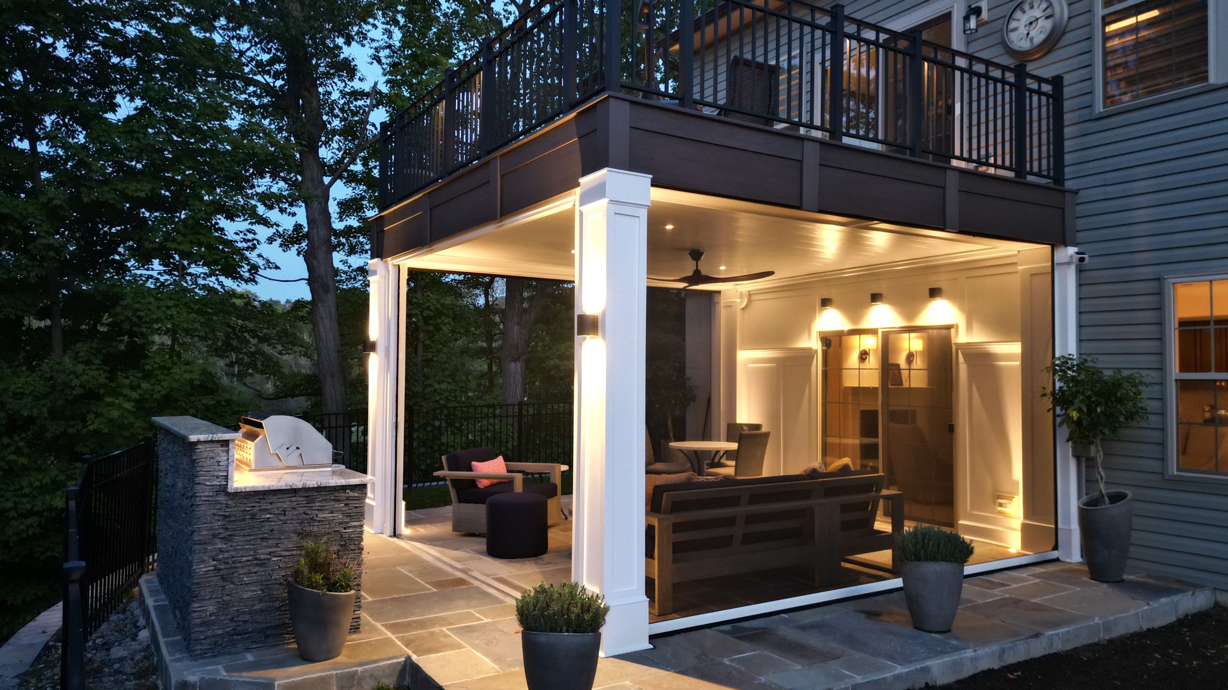 cozy finished under-deck lounge with recessed lighting, ceiling fan, and nearby stone grill station