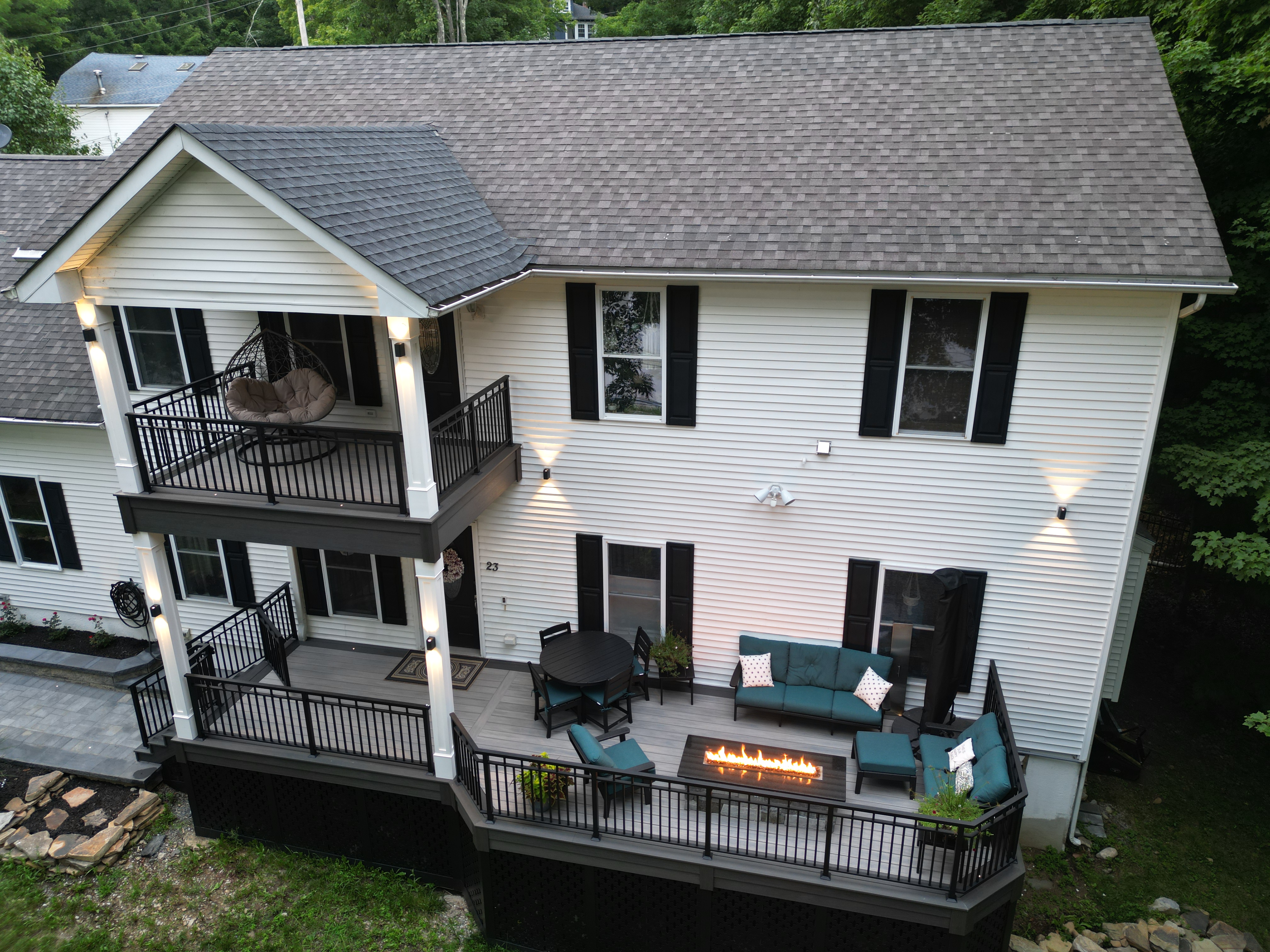 two-level deck with deck lighting on railings and columns, featuring outdoor seating and a linear fire feature