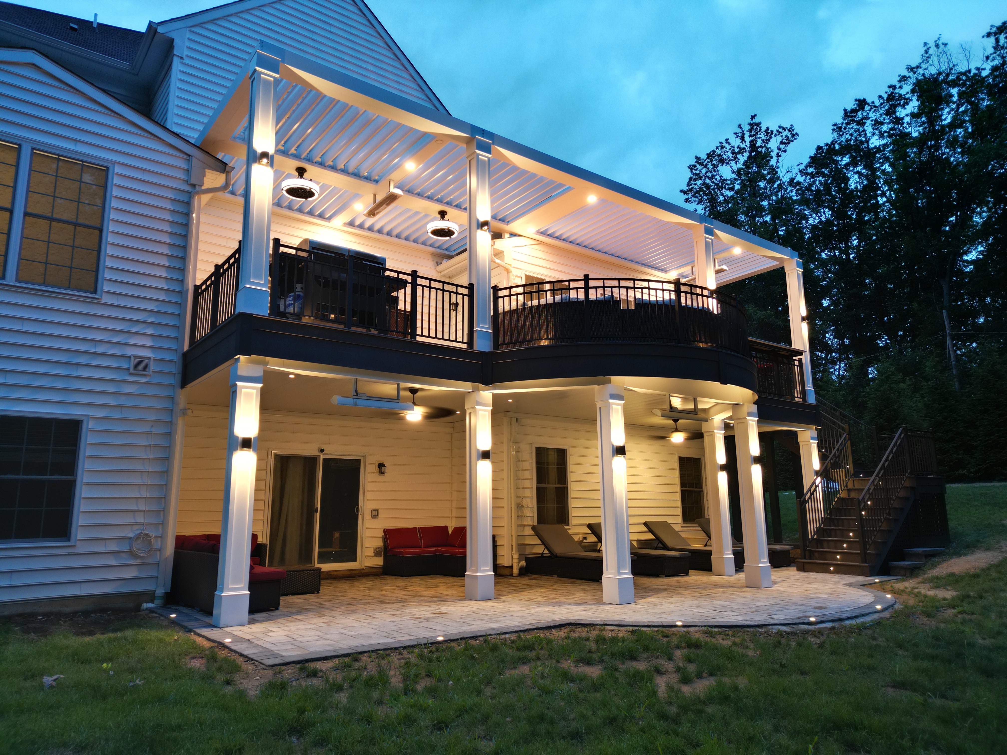 multi level deck with integrated deck lighting on stairs and columns, louvered roof with ceiling lights, and outdoor lounge seating