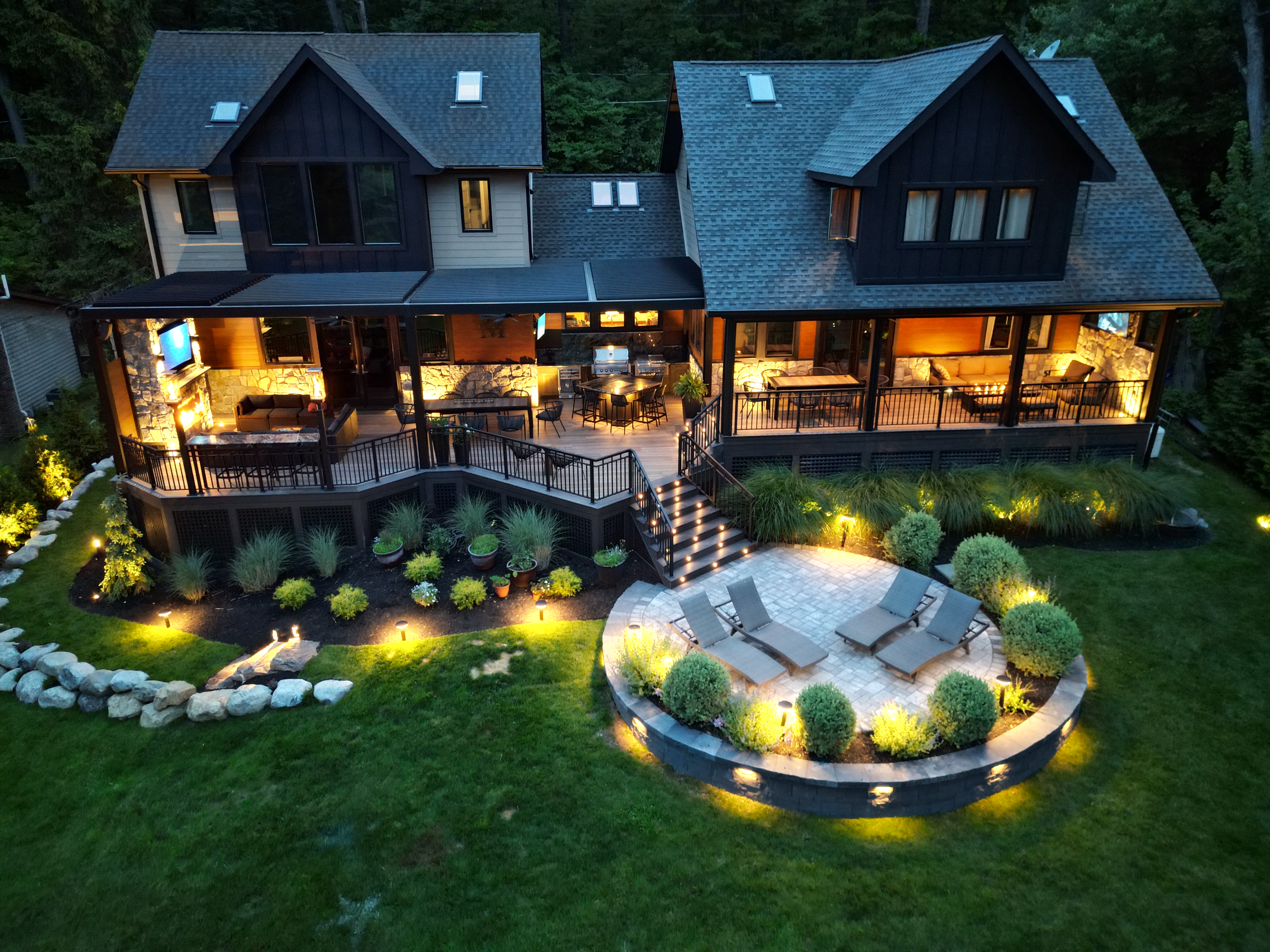 modern multi-level deck with covered outdoor living, step lighting, and elevated patio lounge area