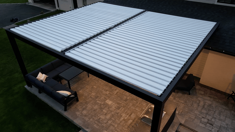 modern backyard patio with motorized louvered roof in motion, showing adjustable aluminum louvers opening and closing above outdoor seating and paver flooring