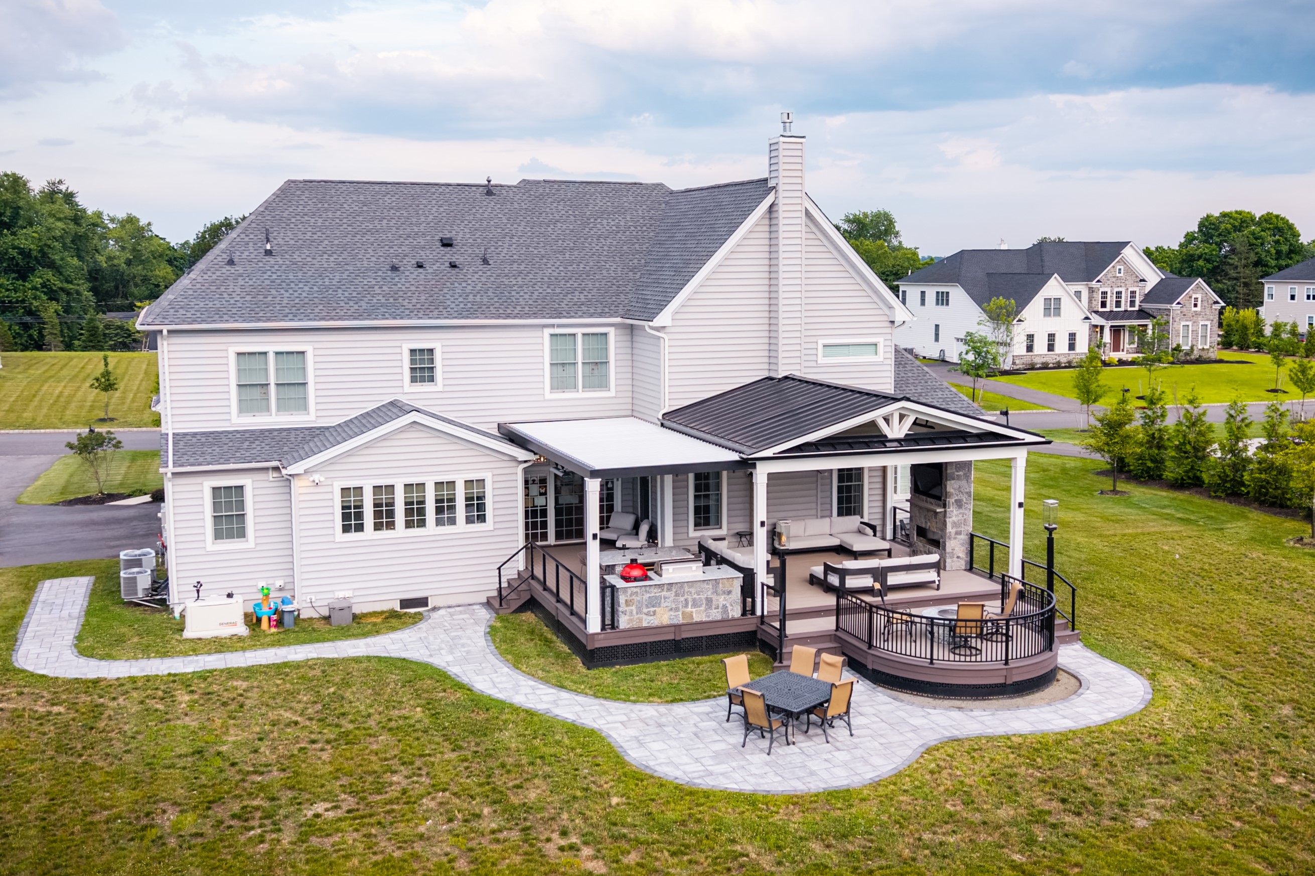elegant backyard deck with curved composite lounge platform, cable railing, built-in stair lighting, outdoor dining area, and integrated fire pit seating